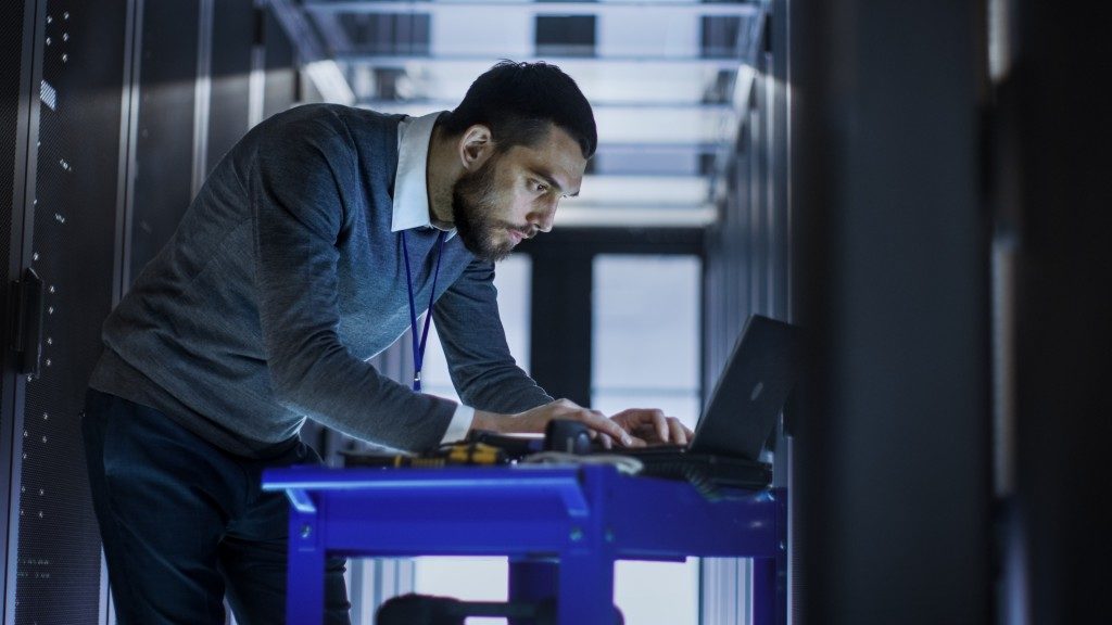 man typing while inside the server room