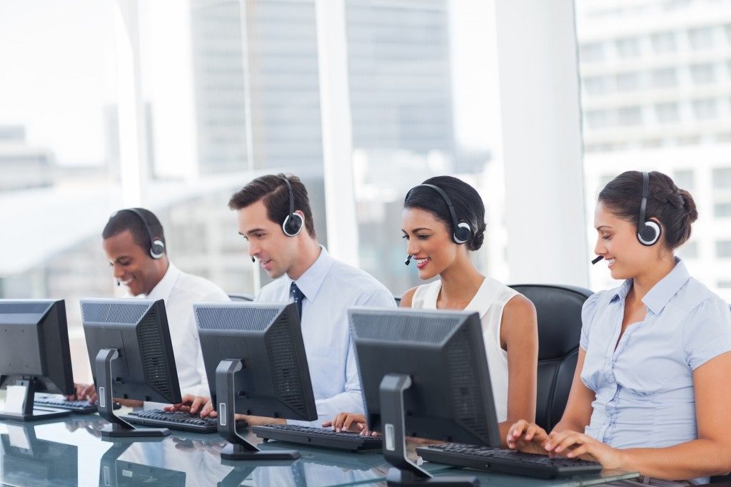 Line of call centre employees working on computers